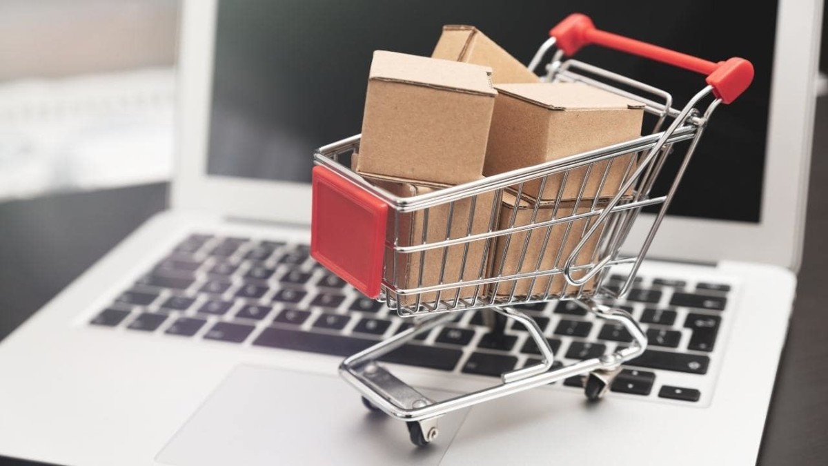 Small shopping trolley with boxes on a laptop keyboard
