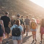 People walking on dirt road near mountain during daytime