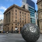 Silver globe statue outside of a bank in australia