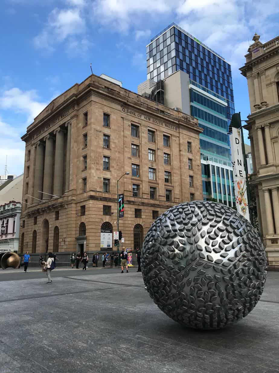 Silver globe statue outside of a bank in australia