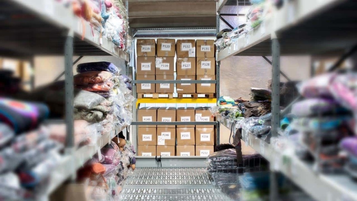 A part of wholesaling warehouse with clothes on the shelves and stored numbered boxes