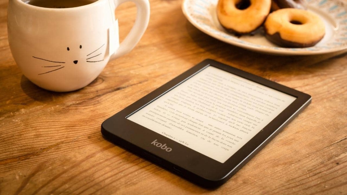 Kobo e-reader next to a plate of doughnuts and a cup of hot coffee