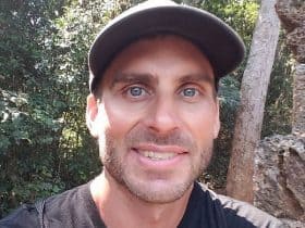 Joe Lannen wearing a cap and smiling to the camera