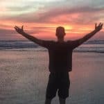 Silhouette of Cameron Woodsum with open arms during sunset in Desa Potato Head, in Bali, Indonesia