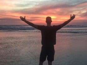 Silhouette of Cameron Woodsum with open arms during sunset in Desa Potato Head, in Bali, Indonesia