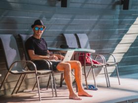 Man outdoors using laptop in the pool area