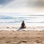 Woman sitting on seashore in Manly Beach, Australia