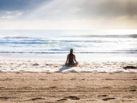 Woman sitting on seashore in Manly Beach, Australia