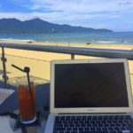 Laptop and drink near a beach in Da Nang, Vietnam