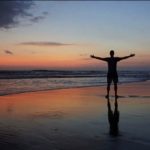 Silhouette of Cameron Woodsum with open arms during sunset in Desa Potato Head, in Bali, Indonesia