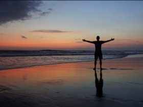 Silhouette of Cameron Woodsum with open arms during sunset in Desa Potato Head, in Bali, Indonesia