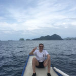 Tom Crowe doing the peace sign while sitting in a boat