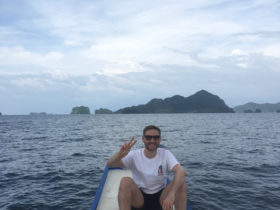 Tom Crowe doing the peace sign while sitting in a boat