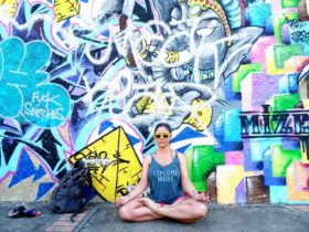 Jade doing yoga in front of a wall with graffiti