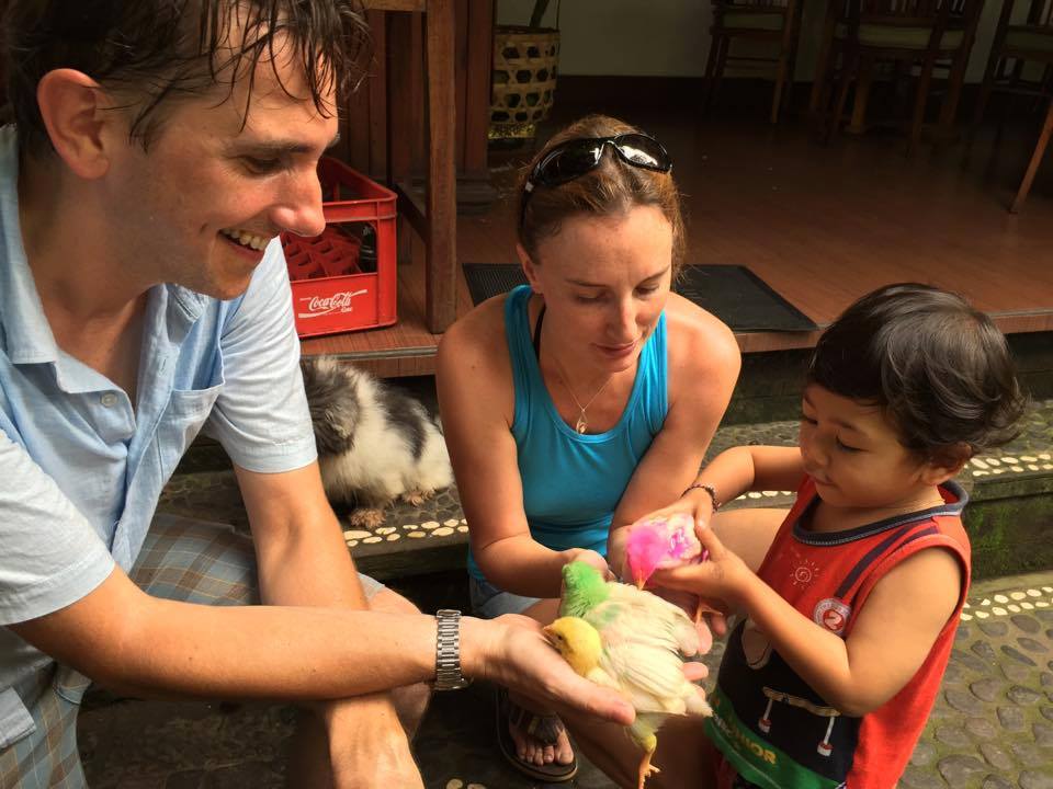 A small child hands Jane Thomas and friend a chick that has been dyed hot pink