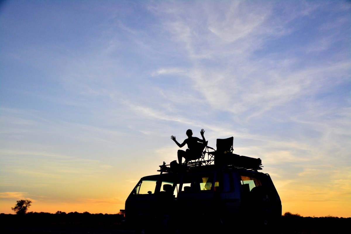 Jane Thomas sits atop the synchro in the heart of the Kalahari as the sun sets behind her