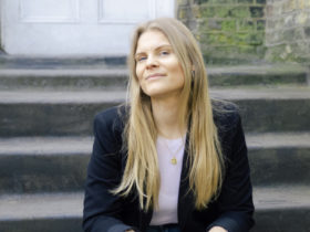 Maria Eilersen sitting in stairs in front of a brick house