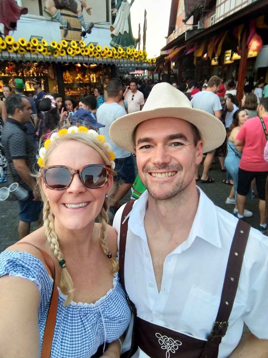 Brian David with his wife Katie standing in a crowd at Oktoberfest as they wear traditional German clothing