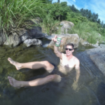 Cam Woodsum smiling and enjoying a beer in a sunny day in the lake