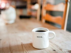 a white mug with the word begin is sitting on a wooden table