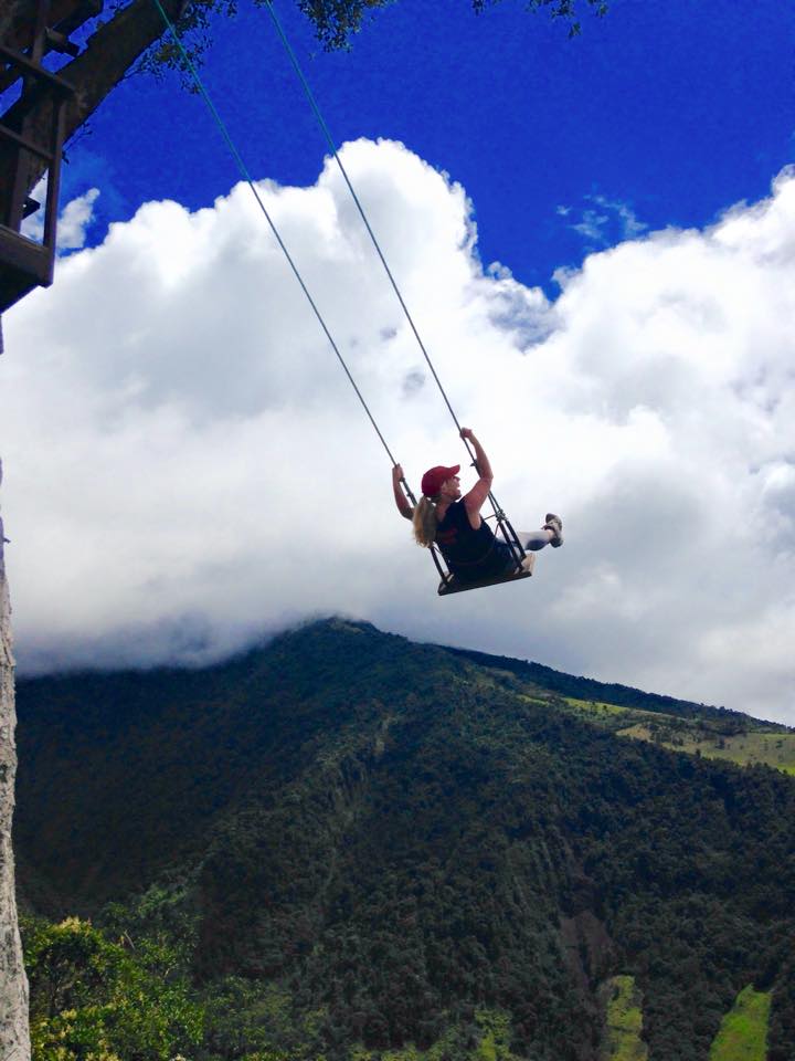 Angela Faith Martin on a huge swing with mountains in front of her