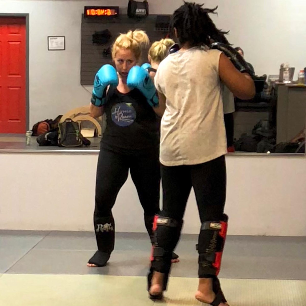 Angela Faith Martin practicing jiu jitsu while wearing turquoise hand wraps 