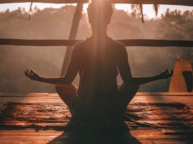 A Woman taking a morning yoga session peering into the jungle in Bali.