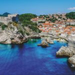 an aerial view of the west bay of dubrovnik croatia shows bright blue water amid the ancient city behind