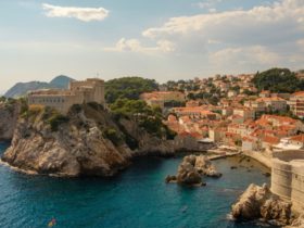 city view of Dubrovnik, croatia, with the ocean in front and the old buildings with orange roofs.
