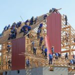 A very large group of people collectively building a house together