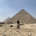 Sarah Archer stands in front of a pyramid in Egypt in the sun