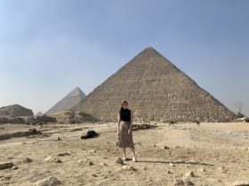 Sarah Archer stands in front of a pyramid in Egypt in the sun