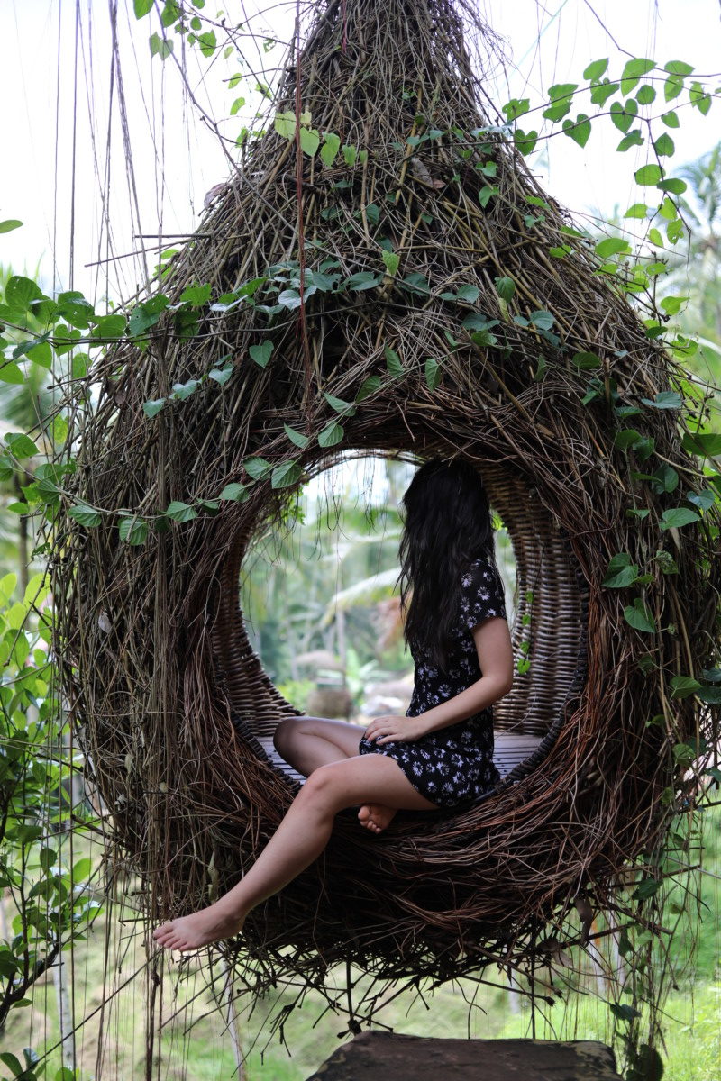 Deya sits in a swinging chair meant to mimic a bird's nest in Bali