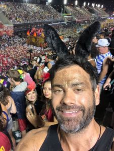 Dirk Bruwer takes a selfie while wearing grey bunny ears as he stands in a massive crowd of people at carnival in Brazil