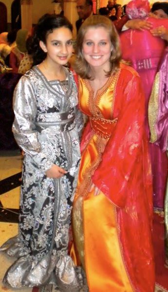 Katherin conaway stands with another female while both wearing ornate dresses