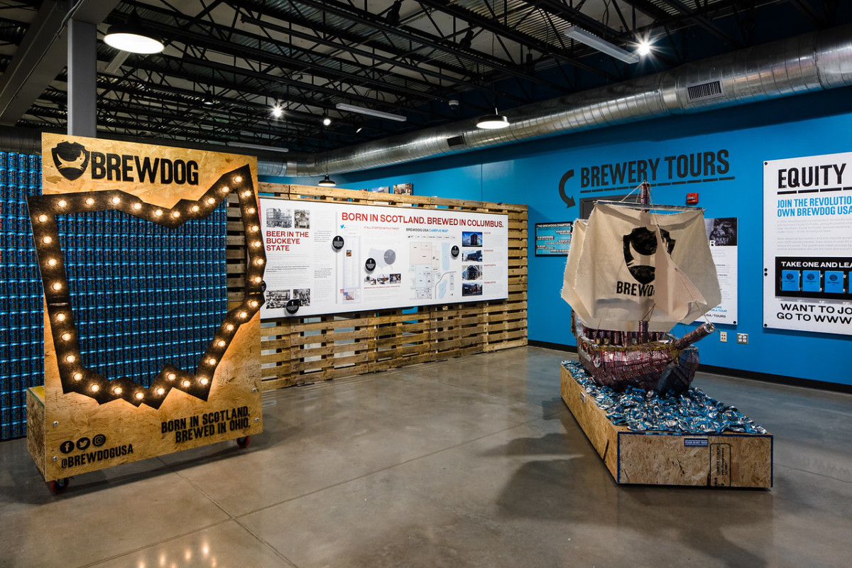A BrewDog USA display at a trade show with merchandise on shelves
