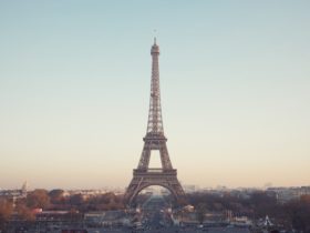 a shot of the eiffel tower from a good distance away shows it with a hazy, multicolored sky