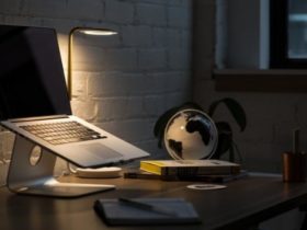 A macbook on a laptop stand on a work desk at night