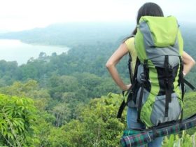 Young female traveler enjoying the view of on top of a hill after a long hike