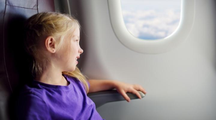 Little girl in the window seat of an airplane