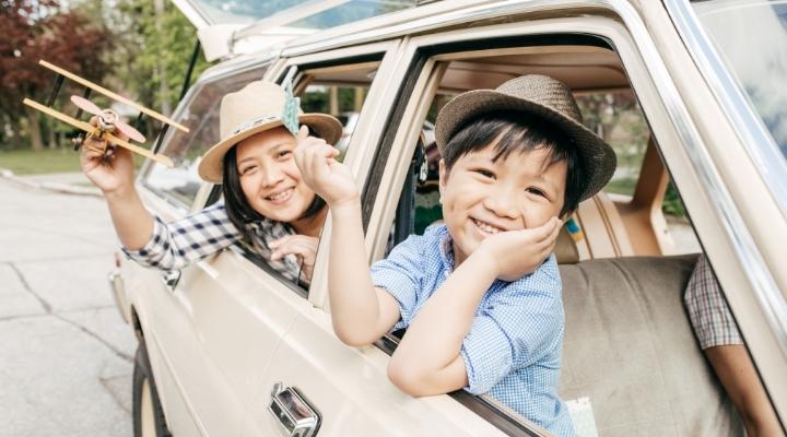 Mom and kid waving through the car window