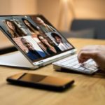 CEO in front of their laptop, talking to 6 employees via video call