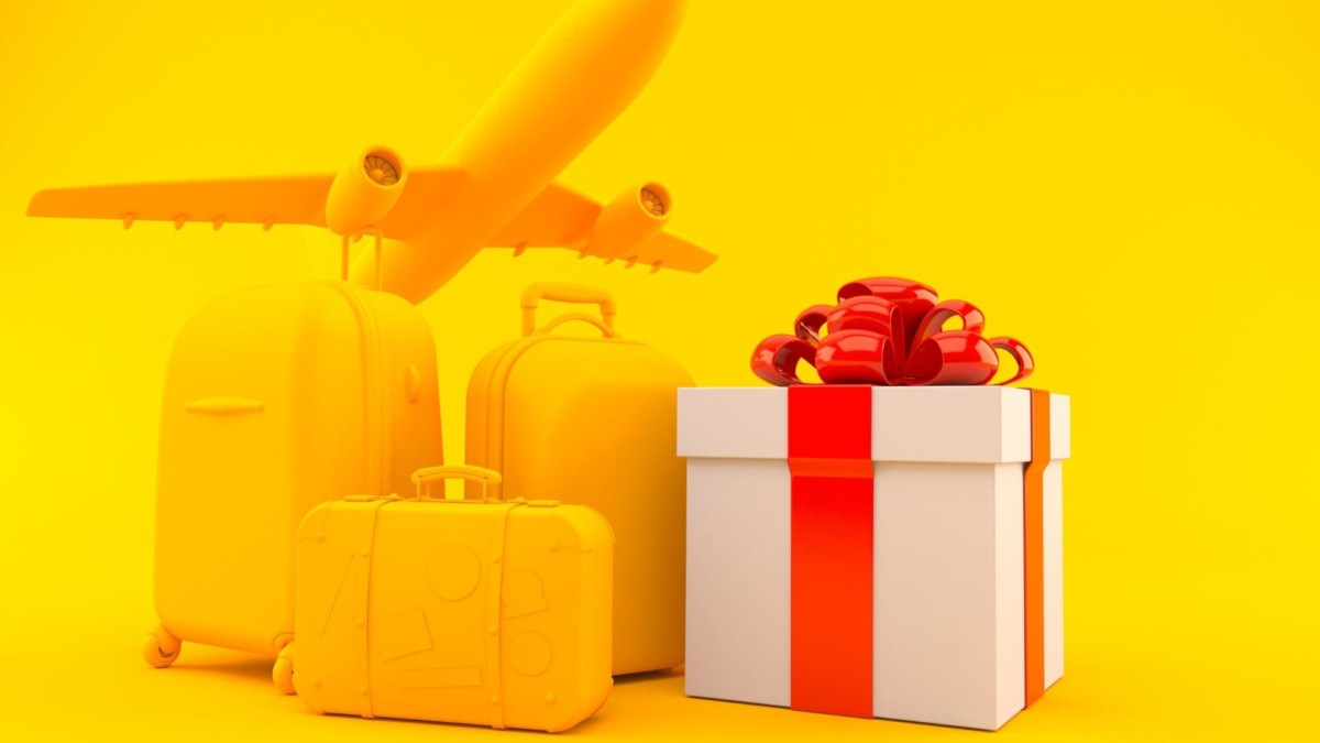 Yellow luggages beside a gift box