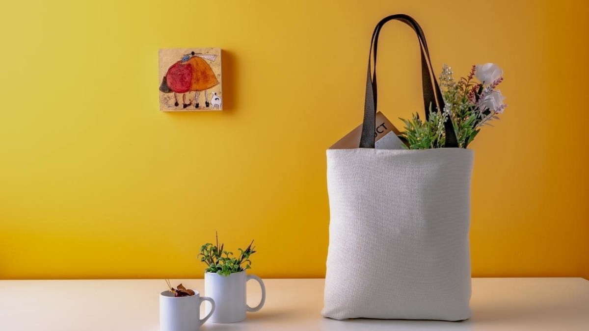 Travel tote bag filled with numerous items on a table